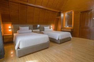 a bedroom with two beds and a mirror at PULAU LIMA Resort in Serang +11 photos