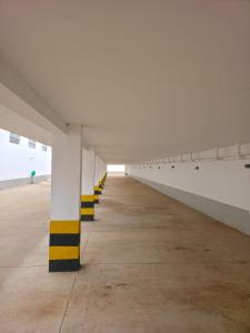 a large white building with yellow and white columns at Pousada Alvorada in Engenheiro Coelho