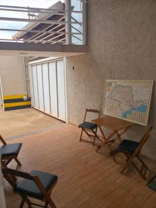 a room with a table and chairs and a map at Pousada Alvorada in Engenheiro Coelho