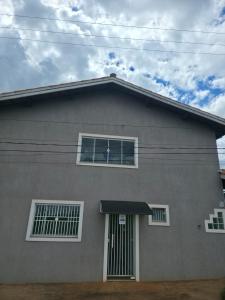 a gray house with a black awning on it at Pousada Alvorada in Engenheiro Coelho