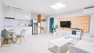 a kitchen and a living room with a table and chairs at Airini Pension in Damyang
