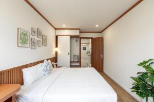 a bedroom with a large white bed in a room at KOA Apart Hotel Phu Quoc in Phú Quốc