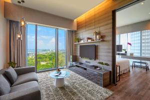 a living room with a couch and a tv at Pan Pacific Serviced Suites Beach Road, Singapore in Singapore