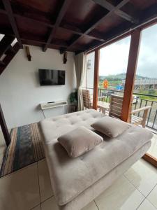a large couch sitting in a room with a television at Cottage Linggayoni Dieng in Diyeng