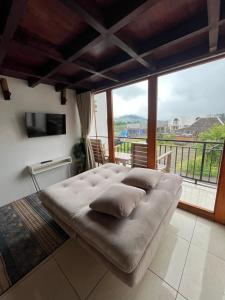 a large couch in a room with a large window at Cottage Linggayoni Dieng in Diyeng