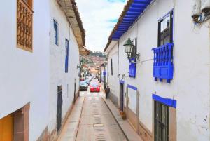 an alley with cars driving down a street with buildings at Cusco - Flor de Loto in Cusco