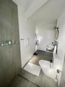 a white bathroom with a toilet and a sink at Lido Dikwella in Dickwella +63 photos