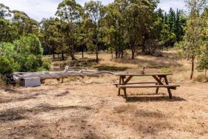 a picnic table in the middle of a field at Tiny Divine Farmstay by Tiny Away in Korweinguboora