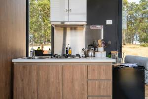 a kitchen with a sink and a stove and a window at Tiny Divine Farmstay by Tiny Away in Korweinguboora