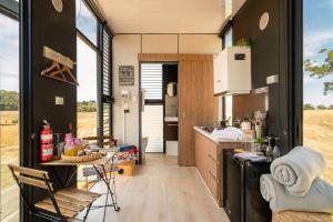 a kitchen in a tiny house with a table at Tiny Divine Farmstay by Tiny Away in Korweinguboora
