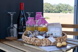 a basket of wine and honey on a table at Tiny Divine Farmstay by Tiny Away in Korweinguboora +15 photos
