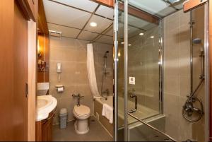 a bathroom with a shower and a toilet and a sink at First Hotel in Taipei +35 photos