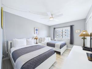 a bedroom with two beds and a ceiling fan at Sandcastles 2BR2BA Cocoa Beach Ocean Views! in Cocoa Beach +44 photos