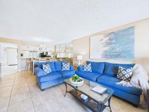 a living room with blue couches and a table at Sandcastles 2BR2BA Cocoa Beach Ocean Views! in Cocoa Beach
