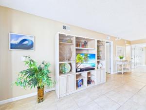 a living room with white shelves and a plant at Sandcastles 2BR2BA Cocoa Beach Ocean Views! in Cocoa Beach