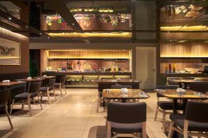 a restaurant with tables and chairs and a bar at Pan Pacific Serviced Suites Beach Road, Singapore in Singapore
