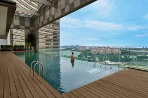 a man standing in a swimming pool on a building at Pan Pacific Serviced Suites Beach Road, Singapore in Singapore