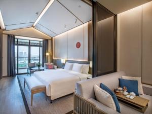 a hotel room with a bed and a couch at Steigenberger Hotel Chongqing in Chongqing +27 photos