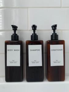 three bottles of soap and shampoo on a shelf at Appartements Saint-Alexandre in Longueuil +19 photos