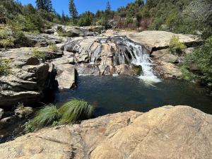 a waterfall on the side of a rocky mountain at Cedar Springs Retreats in North Fork