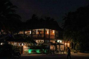 a building at night with a person walking in front of it at Hello Ocean View in Funadhoo