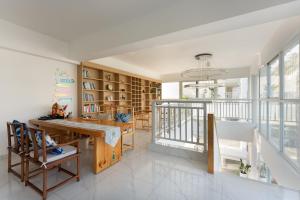 a living room with a table and chairs and a balcony at Langying Intelligent Guesthouse in Sanya