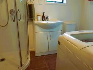 a small bathroom with a sink and a shower at Manukorihi Sweet Guesthouse in Waitara +31 photos