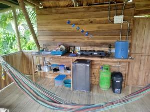 a hammock in a cabin with a kitchen in it at Siwi Lodge in Cañaveral
