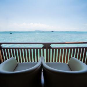 two chairs on a balcony overlooking the ocean at PULAU LIMA Resort in Serang