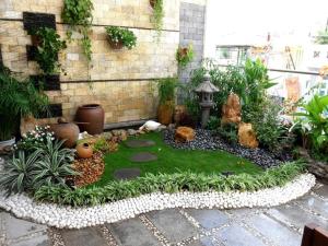 a miniature garden with a bird bath and plants at nhà nhỉ phát thành in Kon Rung (1)