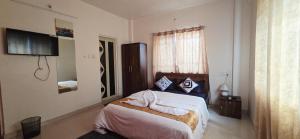 a bedroom with a bed with two towels on it at Sunshinee Villa in Pune