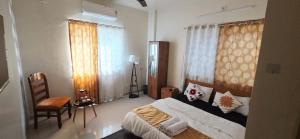 a bedroom with a bed and a chair in it at Sunshinee Villa in Pune
