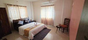 a bedroom with a bed and a chair at Sunshinee Villa in Pune +5 photos