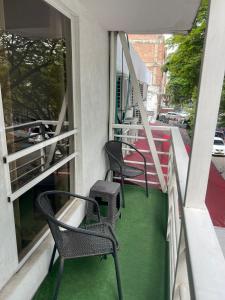 two chairs and a table on the balcony of a building at JARDIN DE TEQUENDAMA HOTEl in Cali