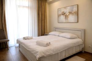 a bedroom with a bed with two towels on it at Stylish House in Kutaisi