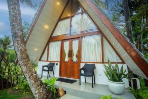 a round house with a large window and two chairs at River Bend Nook in Ahangama