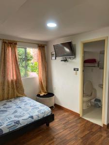 a bedroom with a bed and a flat screen tv at JARDIN DE TEQUENDAMA HOTEl in Cali