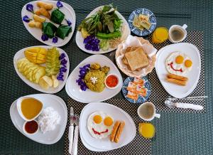 a table full of plates of food with eggs and vegetables at VILLA DIVA STAR in Ko Yao Noi