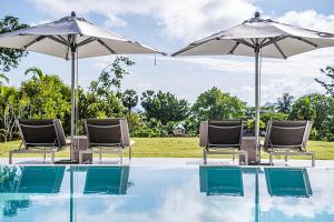 a group of chairs and umbrellas next to a swimming pool at VILLA DIVA STAR in Ko Yao Noi