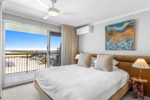 a bedroom with a bed with a view of the ocean at Joanne Apartments in Caloundra +107 photos