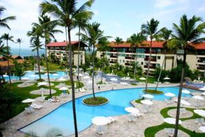 a resort with a pool and chairs and palm trees at Marulhos Resort in Porto De Galinhas +2 photos