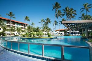 a swimming pool at a resort with palm trees at Marulhos Resort in Porto De Galinhas