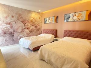 a bedroom with two beds and flowers on the wall at Pool villa Cream Darin in Ban Hua Phrong