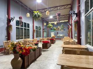 a restaurant with tables and chairs and flowers in a room at Guitar Thai Style Pool House in Ao Nang Beach