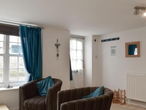 a living room with two chairs and a window at Windjammer Cottage in Swanage