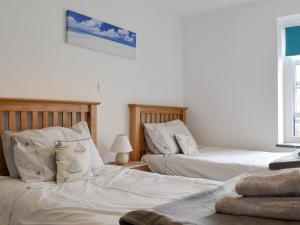 two beds sitting next to each other in a bedroom at Windjammer Cottage in Swanage +5 photos