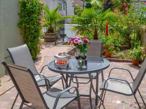a table with chairs and a bowl of flowers on a patio at Samphire Lodge in Brixham