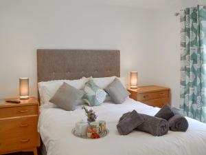 a bed with a tray of towels and candles on it at Samphire Lodge in Brixham