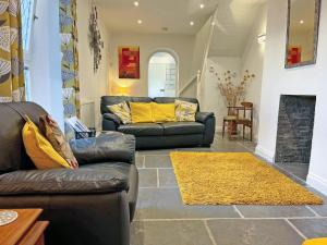 a living room with two couches and a yellow rug at Samphire Lodge in Brixham