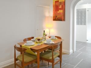 a dining room with a wooden table and chairs at Samphire Lodge in Brixham +6 photos